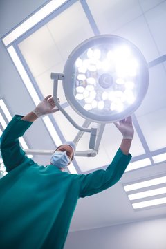 Surgeon adjusting surgical light in operation theater