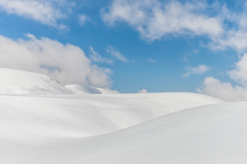 Fototapeta na wymiar Snow hills against clear blue sky