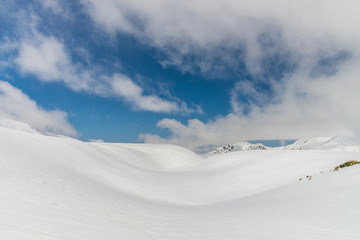 Snow hills against clear blue sky