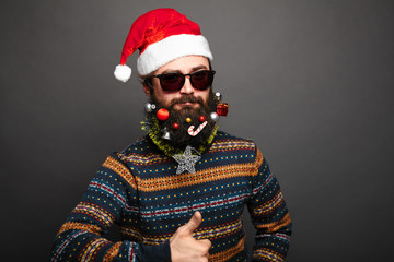 Bearded male in santa hat shows thumbs up.