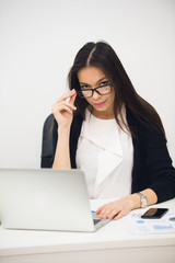 Young businesswoman sitting in office working. Smiling and looking at camera