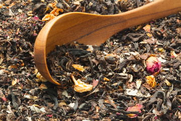 Wooden spoon on pile of dry leaf tea and flower. Can use as a food or beverages background