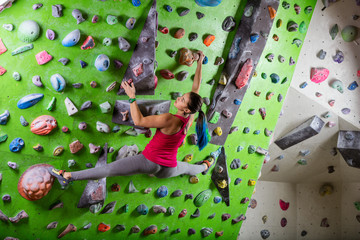 Young woman bouldering in climbing gym © Andrey Bandurenko