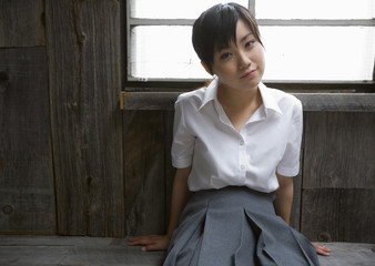 Girl sitting on floor in school uniform