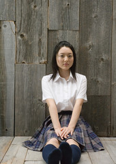 Girl sitting on floor in school uniform