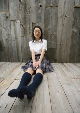 Girl sitting on floor in school uniform