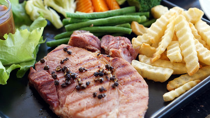 Pork chop steak with pepper, fries and vegetable salad dish