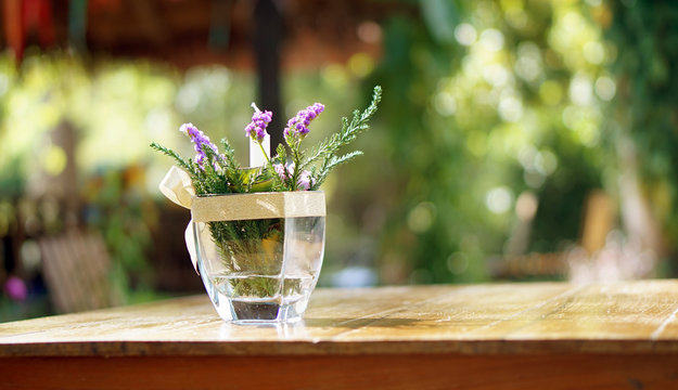 Purple Flower In Vase On Wood Table Copy Space Blur Nature Backg