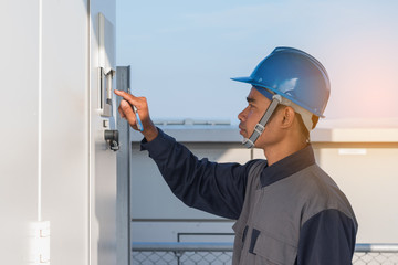 engineer or electrician working on checking and maintenance equipment at green energy solar power plant: checking status inverter
