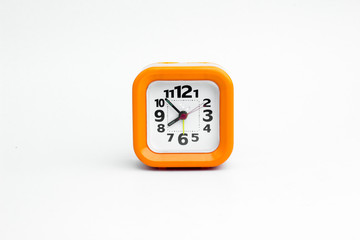 Clock orange with white backdrop..Orange clock on a white backgr