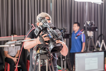 Obraz na płótnie Canvas man use digital video camera with lens equipment in professional