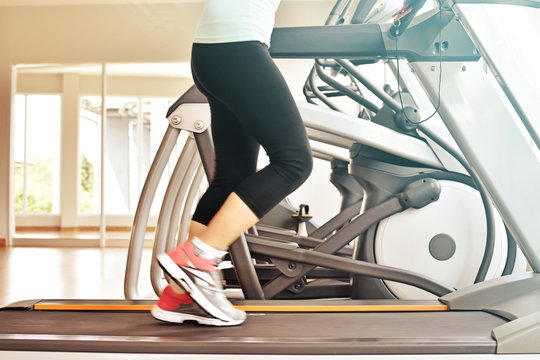 Woman running on a treadmill in a fitness club, sport in the fit