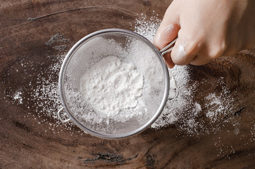 Wheat flour in a sieve on wooden background,food ingredient,prepare for cooking or baking