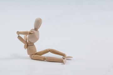 Wooden figurine sitting with hands on back