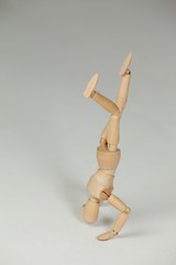 Wooden figurine performing a headstand