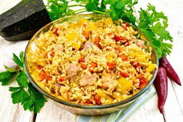 Rice with chicken and zucchini in glass pan on light board