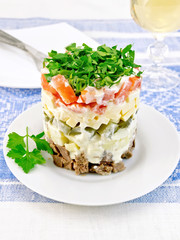 Salad with beef and tomato on blue tablecloth