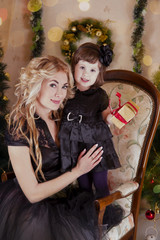 Mother and daughter under Christmas tree