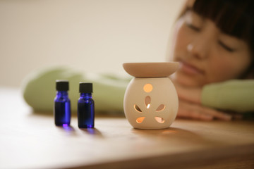 Woman lying beside an aromatherapy burner 