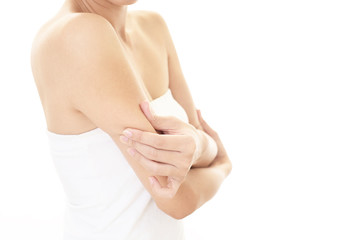 二の腕をつまむ女性