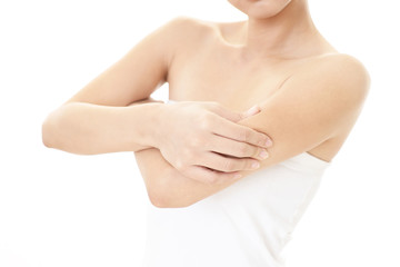 二の腕をつまむ女性