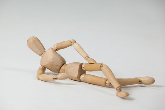 Wooden figurine reclining on the floor