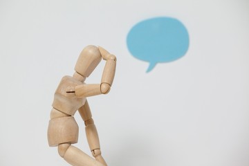 Tensed wooden figurine with hand on head