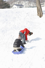 Fototapeta na wymiar Children at play sledding