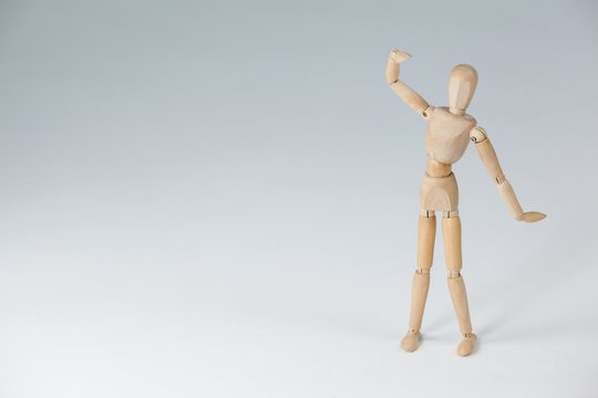 Wooden figurine standing with hand raised