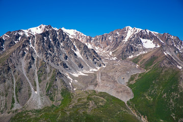 Green grassy mountain valley with ice peaks, Central Tien-Shan,