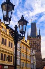 Fototapeta na wymiar Prague street architecture. Tower and street light on cloudy sky background