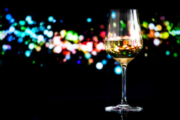glass of white wine against a glowing bokeh - copy space, select