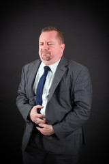 Handsome man doing different expressions in different sets of clothes: stomachache