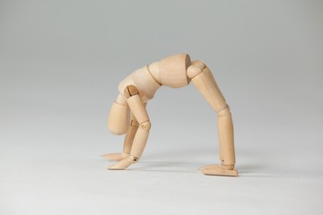 Wooden figurine exercising on floor