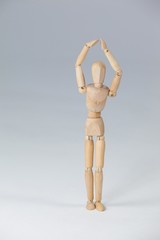 Wooden figurine standing with hands raised