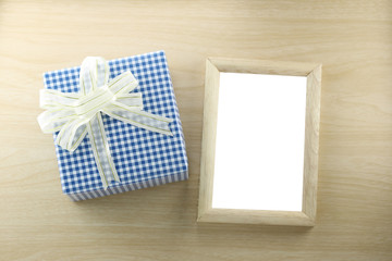Blue gift box place near wooden frame on the wood floor.