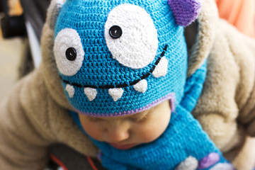 Kid in a funny hat. The boy walks in the fresh air. The kid is playing in the yellow leaves

