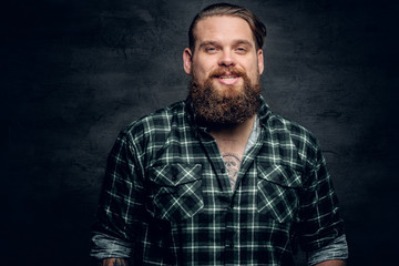 Obraz premium Smiling bearded male in a green plaid shirt.
