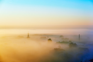 city at dawn surrounded by fog