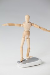 Wooden figurine standing with arms spread on a mouse