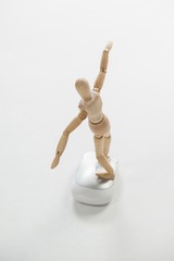 Wooden figurine standing with arms spread on a mouse