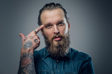 Bearded man with tattoos on arms.