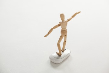 Wooden figurine standing with arms spread on a mouse