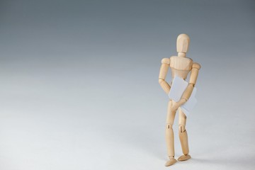 Wooden figurine standing and holding documents