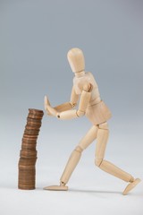 Wooden figurine preventing stack of coins from falling