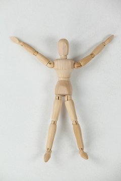 Wooden Figurine Lying On Floor With Arms Spread Wide