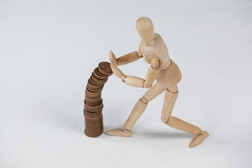 Wooden figurine preventing stack of coins from falling