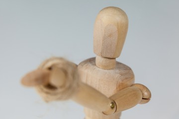 Hands of wooden figurine tied with a rope