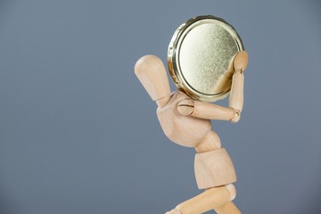 Wooden figurine holding a gold coin