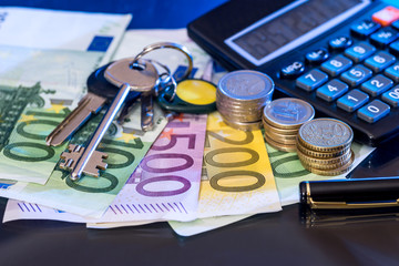 euro coin and banknotes with calculator, pen  isolated on black.